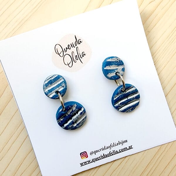 Aros colgantes tipo moneditas en azul con efecto metalizado gastado plateado, hechos a mano de porcelana fría con postes de acero quirúrgico hipoalergénico.