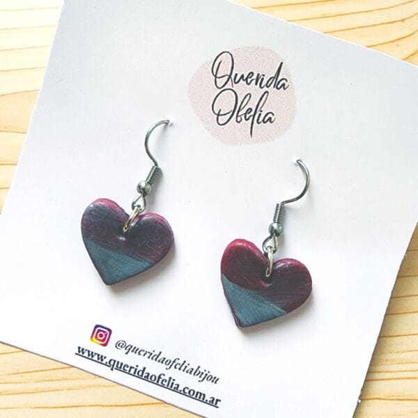 Par de aros de bijouterie en forma de corazón, hechos a mano con combinación plateada y efecto tornasolado, con base de acero quirúrgico hipoalergénico. Ideales para mujeres que buscan accesorios exclusivos y un regalo especial.